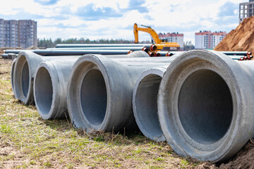 Reinforced concrete storm sewer pipes of large diameter stacked at a construction site. Sewer Large...