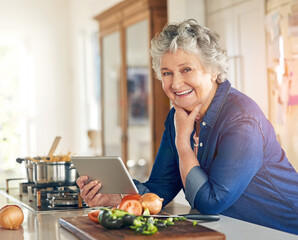 This recipe even comes with a video tutorial. Portrait of a senior woman using a digital tablet while cooking in her kitchen.