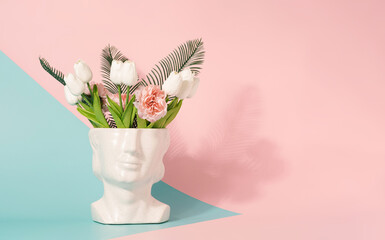 Y2K sculpture head with spring flowers on a pastel pink and blue background. Summertime spring...