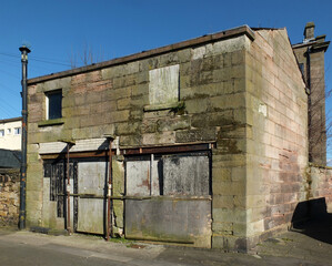 derelict empty abandoned business premises converted from a house with collapsing walls and boarded...