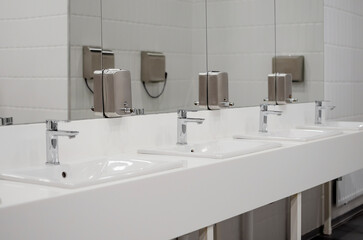 Fototapeta na wymiar faucet with a sink in a public toilet. Modern public toilet interior.