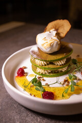 stack of green pancakes with cream close-up