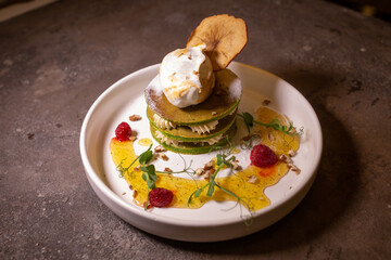 Plate with green pancakes and berry jam