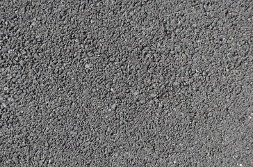 Coarse gray asphalt in daylight, road pavement