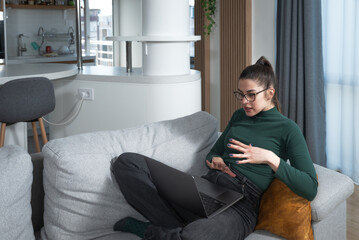 Young woman talking on video call with her psychotherapist doctor after online therapy sessions,...