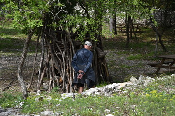 Vieil homme de dos devant une cabane