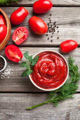 Homemade tomato sauce in white bowl, fresh tomatoes, spices and herbs. Top view