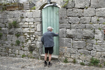 Vieil homme devant une porte verte