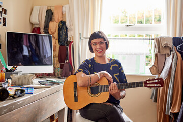 She has music in her soul. Portrait of a stylish young woman sitting in her eclectic toom playing a...