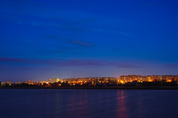 A view of the city at night from a river or lake. Night scenery of a big city