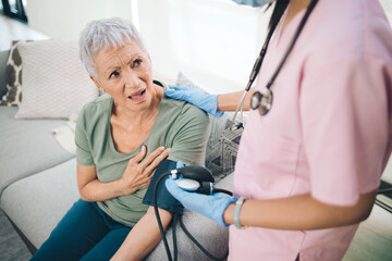 Those arent butterflies. Shot of a concerned older woman having her blood pressure read at home.