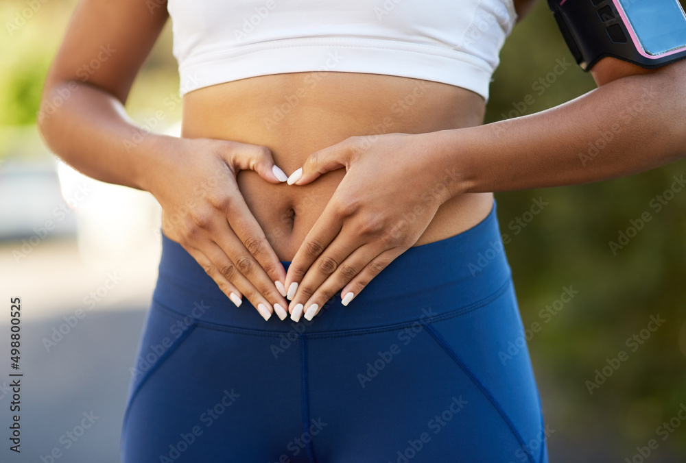 Poster Love your body. Shot of an unrecognizable young woman making a heart shape on her belly.