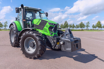 Fototapeta premium powerful agricultural tractor on the site against the blue sky