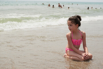 Fototapeta na wymiar Girl playing happily on the shore of the beach, Vera, Spain