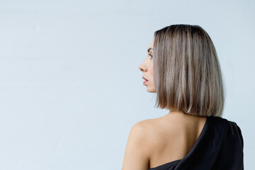 Side view of a woman's short hairstyle looking to the side. Female with dyed hair in profile in a fashionable coloring technique