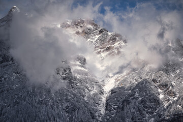Fototapeta na wymiar Very cloudy sky over mountains covered with snow near the alps