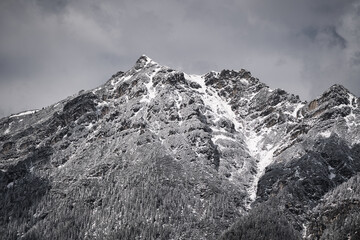 Very cloudy sky over mountains covered with snow near the alps