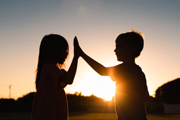 Boy and girl working as a team giving high five 