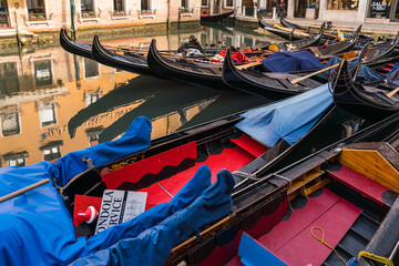 Fototapeta na wymiar Close up of multiple empty gondolas parked by a canal in Venice, Italy 