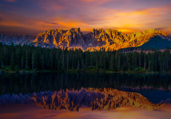 Fototapeta na wymiar Mountains and forest reflecting on the surface of Carezza Lake in the Dolomites, Alps, Italy