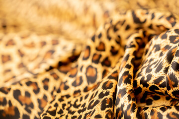 Satin fabric close up background and texture with place for text. Leopard print, silk orange.
