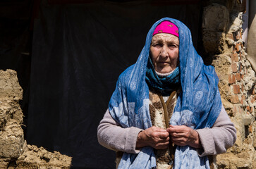 A woman in front of a house destroyed by an explosion. War in Ukraine. Russian aggression against...