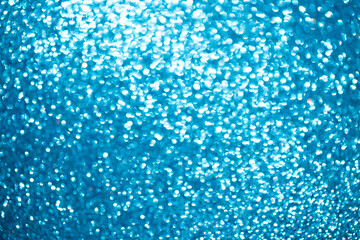 Background light bokeh texture. Beautiful festive Christmas background for the design of congratulations. Nacreous sparkling blue texture.