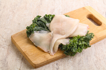 Raw squid over wooden board