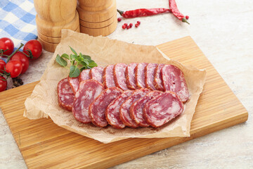 Sliced salami sausages over board