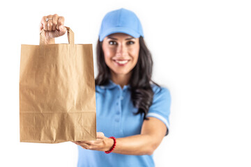 Young dark-haired employee holding a paper takeaway bag in front of her ready for the customer. Isolated background