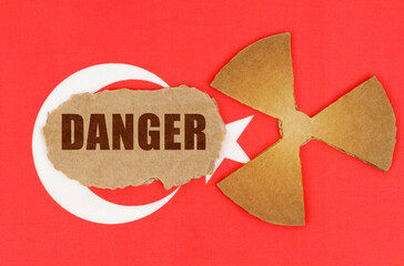 On the flag of Turkey, the symbol of radioactivity and torn cardboard with the inscription - Danger