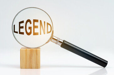 On a white surface there is a cube and a magnifying glass inside which is the inscription - legend