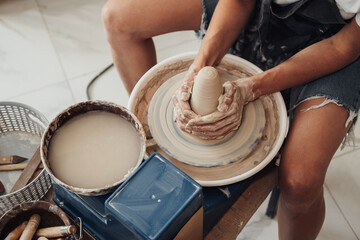 Fototapeta premium Process of Creating Clay Pot, Unrecognisable Female Master Working on a Pottery Wheel in Studio