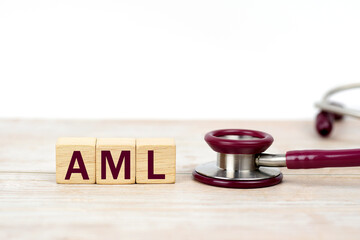 Word AML (Acute Myeloid Leukemia) on wooden blocks and stethoscope on white background. leukemia...