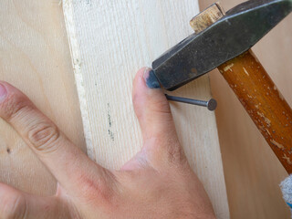 A close-up of an employee missed with a hammer and hit his finger. Bruise, hematoma, injury....