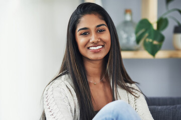 Shes loving her weekend alone. Cropped portrait of an attractive young woman relaxing on the couch...