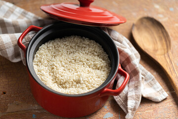 Uncooked Carnaroli risotto rice in pot.