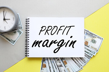 Profit Margins .words on a notepad on a yellow and gray background. next to banknotes