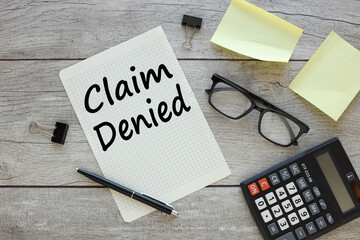 Claim Denied. torn sheet of paper from a notebook with text on the desktop. business concept