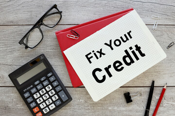 FIX YOUR CREDIT. sheet of paper with text on a red notepad