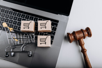 Judge gavel and shopping cart with card boxes on a laptop. Sanctions concept