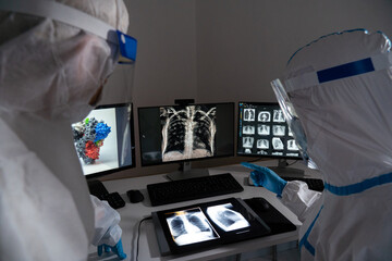 Two doctors examine the results of a patient with covid-19.