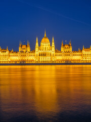 Fototapeta premium Parliament building in Budapest, Hungary. Parliament and reflections in the Danube River. Evening illumination of the building.
