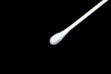 Tip of Q-Tips type cotton swab close up macro on a black background with copy space.