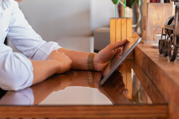 Hands of unknown man using a tablet in an elegant and quiet place. Concept of young businessman.