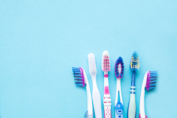 Toothbrushes new and old on a blue background. copy space