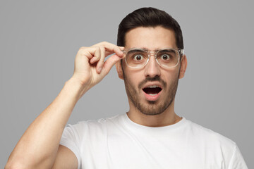 Surprised man shouting oh my god with open mouth, holding glasses - obrazy, fototapety, plakaty