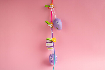 Easter lilac eggs on clothespins on a pink background. Easter concept.
