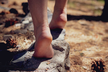 Feet balancing along a stone wall