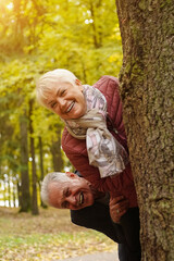 Senior couple laughing and having fun in autumn park. Age is no barrier to fun